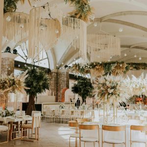 Beautifully decorated wedding hall with chandeliers and floral arrangements, perfect for ceremonies.
